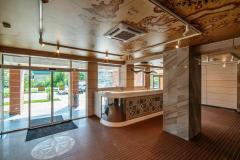 Интерьер с деревянной отделкой, мраморными столешницами и автоматическими раздвижными дверями в жилом комплексе «Каравелла Португалии» в Дагомысе, Сочи