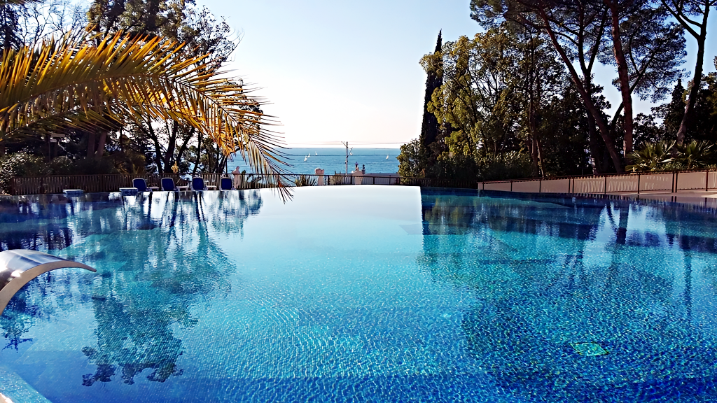 Открытый подогреваемый бассейн в отеле Swissotel Resort Сочи Камелия выполнен в форме цветка камелии. Температура воды составляет +28 градусов Цельсия и поддерживается на этом комфортном уровне круглый год. Особенности бассейна: подводная акустическая система. Звук музыкального сопровождения слышен под водой и не слышен над её поверхностью. Зона отдыха. Вокруг бассейна — просторная зона, обустроенная шезлонгами. Рядом с бассейном располагается летний бар, где можно заказать прохладительные напитки, коктейли и лёгкие закуски, а также детский бассейн для самых маленьких гостей отеля. Глубина основного бассейна — от 1,4 до 1,6 метра. Время работы: без выходных с 09:00 до 21:00. Адрес: Курортный проспект, 89, Сочи.